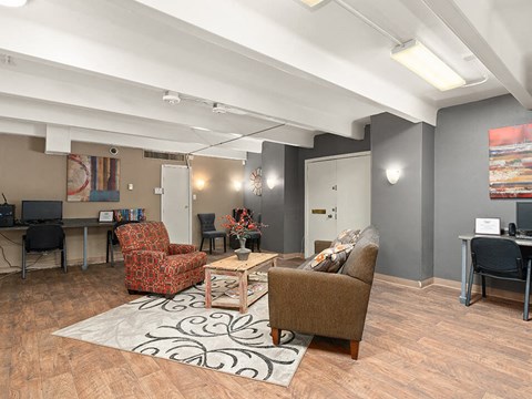 a living room with a couch and chairs and a desk